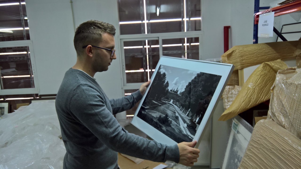 Abel López trabajando con una fotografía de archivo en un laboratorio de conservación.