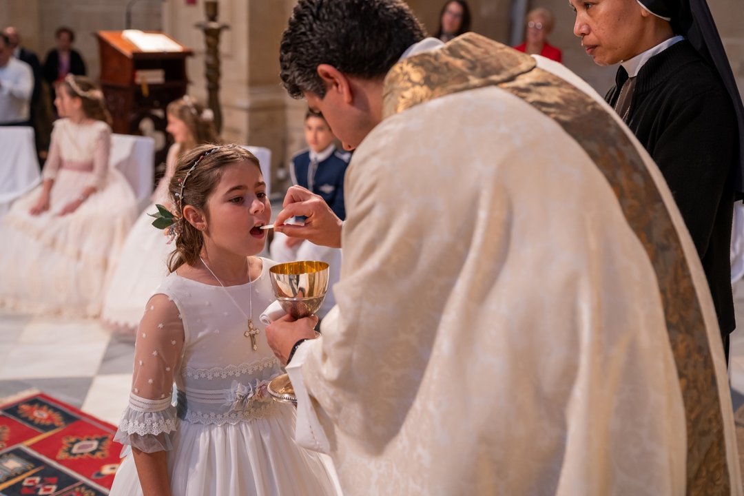 Niña recibiendo su primera comunión durante la ceremonia