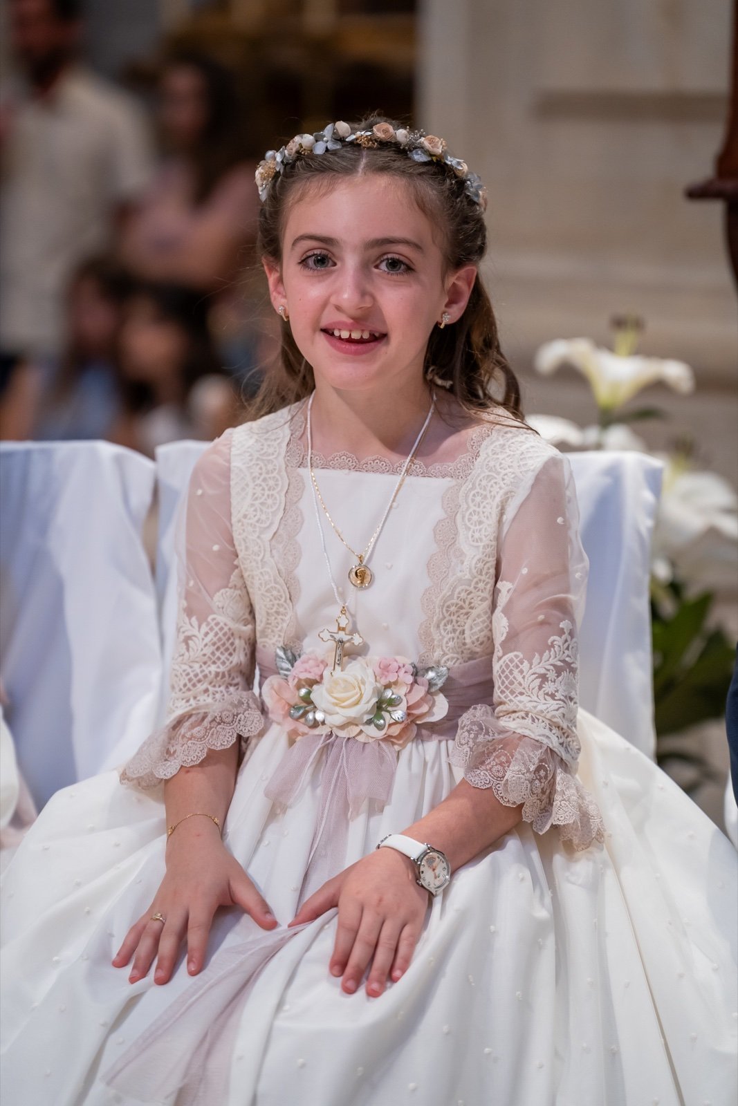 Niña sentada durante la ceremonia de su primera comunión