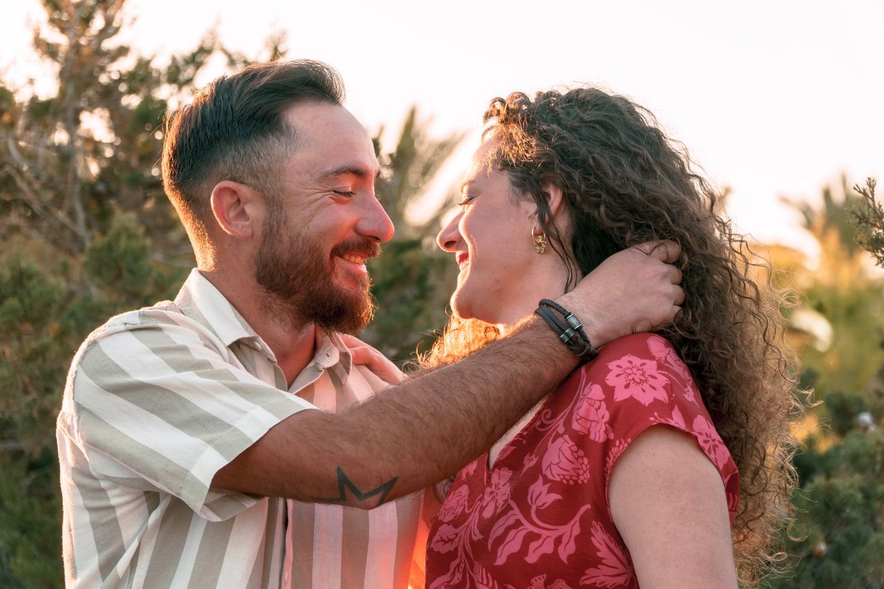Ángela y Sergio sonríen abrazados al atardecer durante su sesión de preboda.