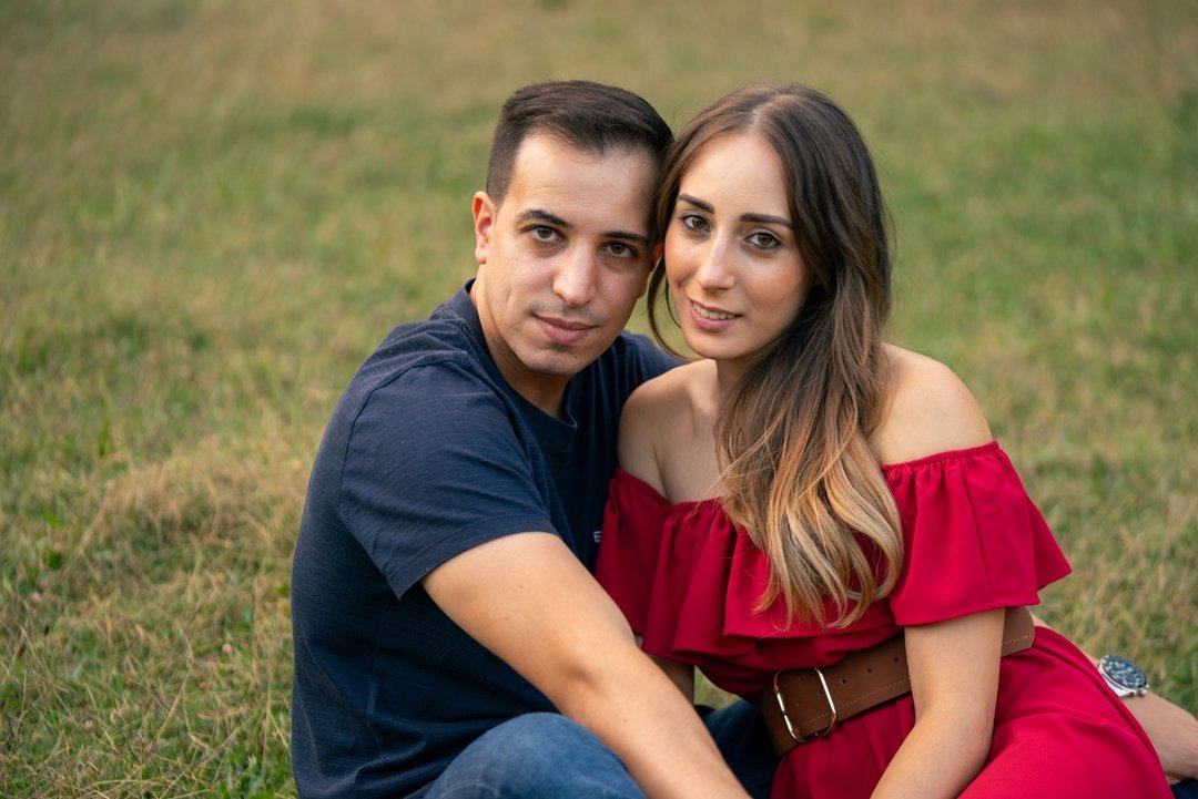 Soraya y Paco sentados juntos sobre la hierba en su reportaje de preboda.