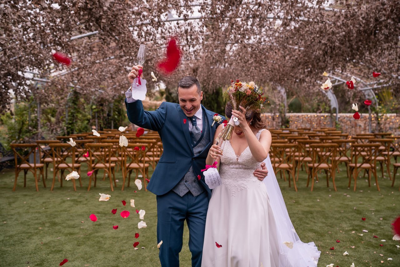 Paco y Rosi celebran su boda entre pétalos, con sus copas y el ramo de novia.